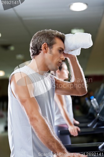 Image of Man Wiping Sweat With Towel At Health Club