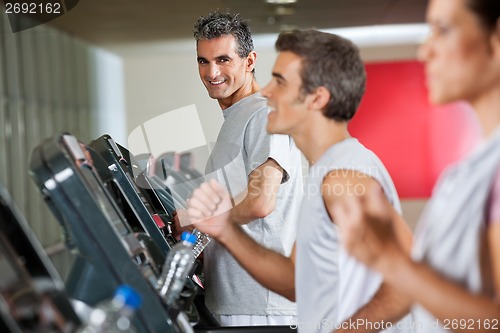 Image of Man Running On Treadmill In Fitness Club