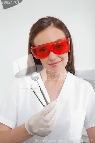 Image of Dental Nurse Holding Angled Mirror And Carver