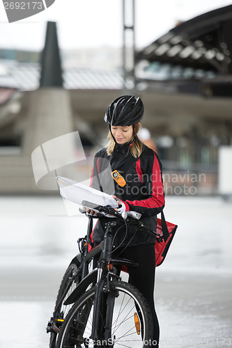 Image of Female Cyclist With Courier Bag And Package On Street