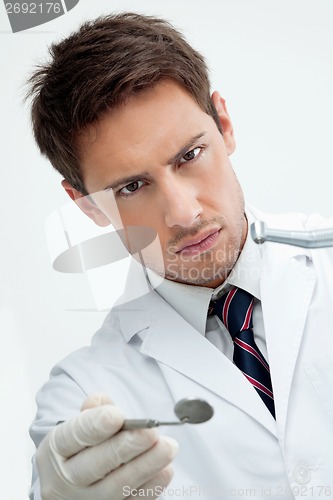 Image of Dentist Holding Drill And Angled Mirror