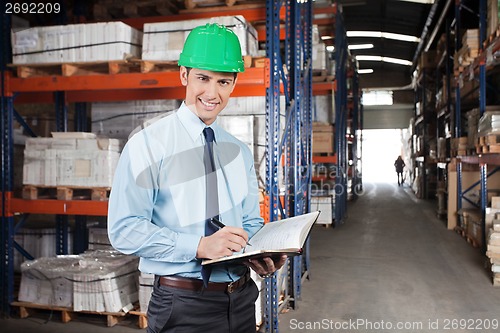 Image of Confident Supervisor With Book At Warehouse
