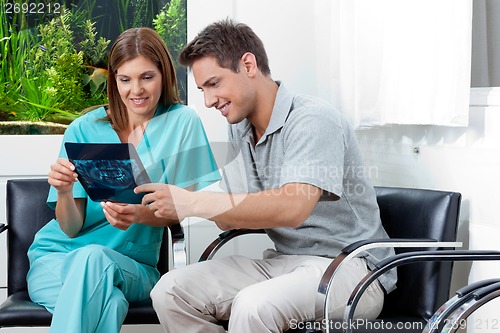 Image of Dentist Showing X-Ray Report To Man