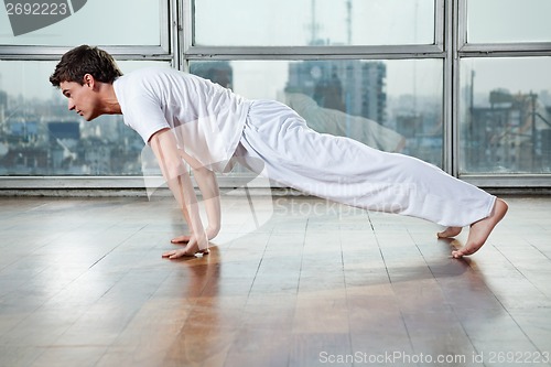 Image of Young Man Practicing Yoga At Gym