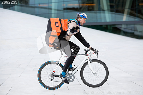 Image of Male Cyclist With Backpack Riding Bicycle