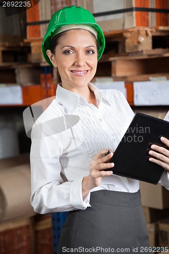 Image of Female Supervisor With Book At Warehouse