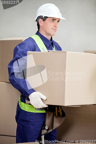 Image of Foreman Lifting Cardboard Box At Warehouse