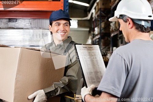 Image of Warehouse Worker Looking At Supervisor With Clipboard