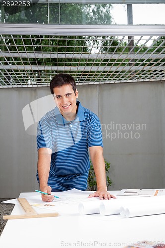 Image of Architect Working On Blueprints