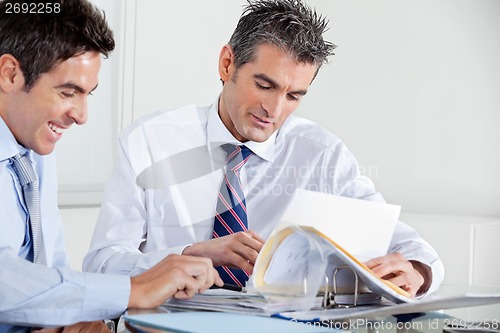 Image of Businessmen Discussing Paperwork In Office