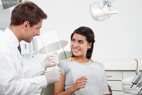 Image of Dentist Holding Thread While Patient Looking At Him