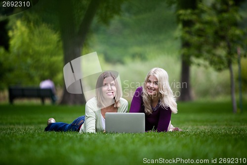 Image of Young Women Using Laptop in Park