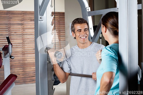 Image of Man Lifting Weights While Looking At Instructor