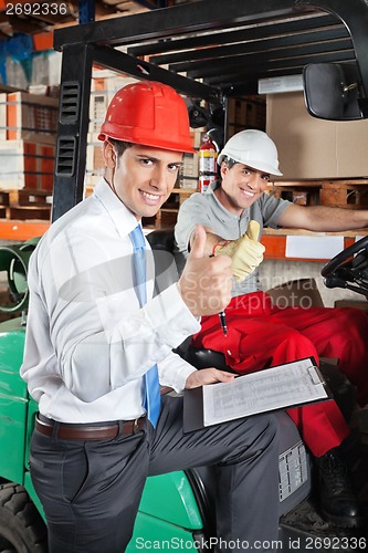 Image of Supervisor And Forklift Driver Gesturing Thumbs Up