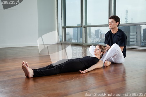 Image of Instructor helping Woman In Yoga Exercise