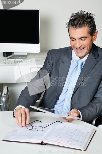 Image of Happy Businessman Using Digital Tablet In Office