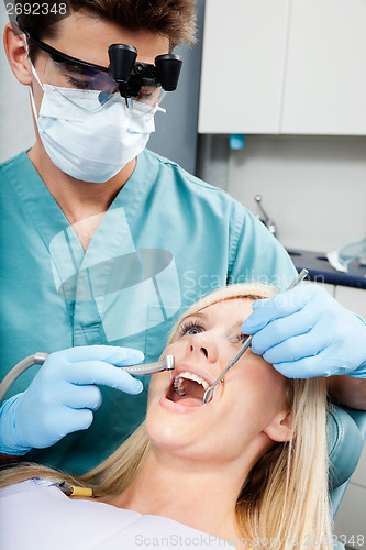 Image of Dentist Treating A Female Patient At Clinic
