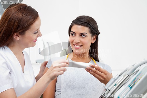 Image of Female Dentist Prescribing Tooth Paste To Patient