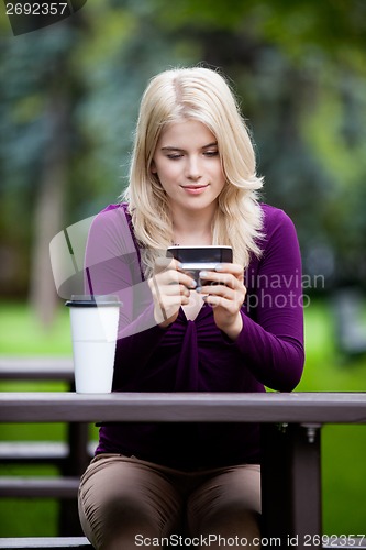 Image of Woman in Park using Cell Phone