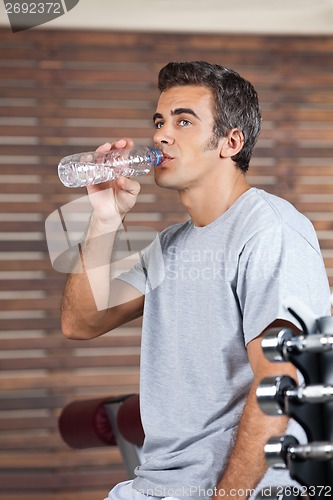 Image of Man Drinking Water From Bottle At Health Club