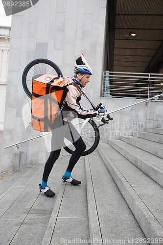 Image of Male Cyclist With Courier Bag And Bicycle Walking Up Steps