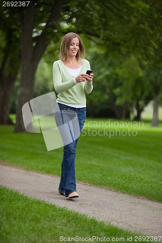 Image of Woman Text Messaging In Park