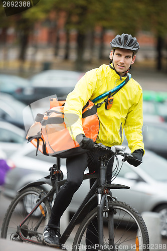 Image of Male Cyclist With Courier Delivery Bag On Street