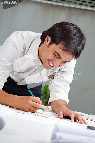 Image of Architect Working On Blueprint