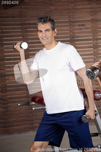 Image of Happy Mature Man Lifting Dumbbells