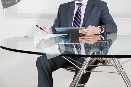 Image of Businessman Using Digital Tablet In Office