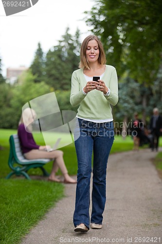 Image of Woman Reading Text Message In Park