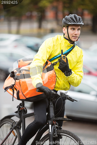 Image of Male Cyclist With Courier Bag Using Walkie-Talkie