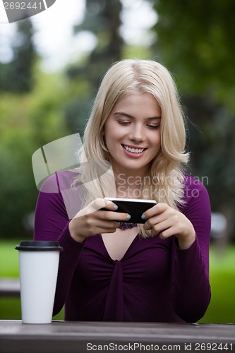 Image of Woman Updating Status on Mobile Phone