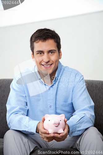 Image of Businessman Holding Piggybank