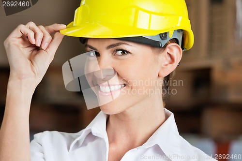 Image of Female Supervisor Touching Hardhat At Warehouse