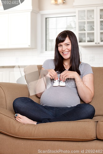 Image of Happy Pregnant Woman Holding Baby Shoes