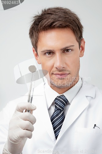 Image of Young Male Dentist Holding Tools