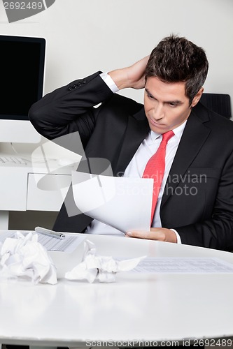 Image of Confused Businessman Working At Desk