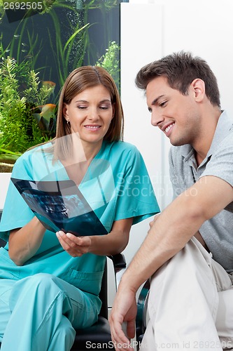 Image of Dentist Showing Patient X-Ray In Clinic