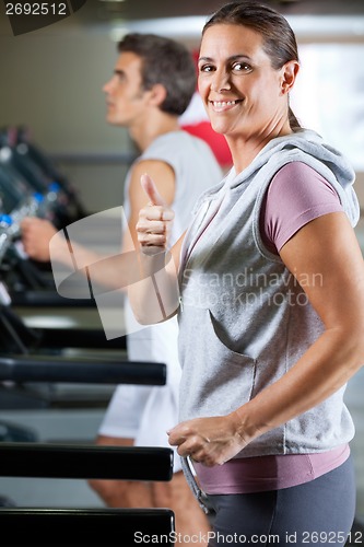 Image of Woman And Man Running On Treadmill