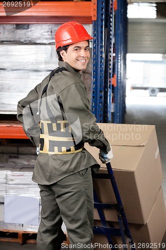 Image of Warehouse Worker Pushing Handtruck