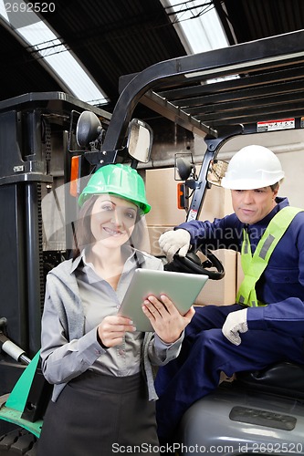 Image of Female Supervisor And Forklift Driver With Digital Tablet