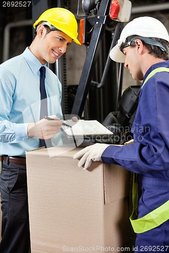 Image of Male Supervisor Showing Clipboard To Foreman