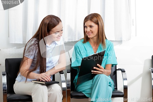 Image of Doctor And Patient With Clipboard In Clinic