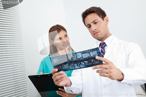 Image of Doctor And Assistant Analyzing Patient's Report