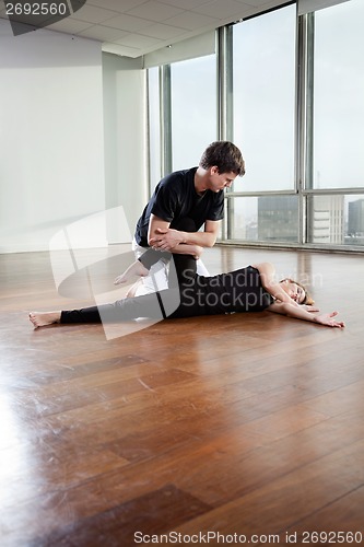 Image of Fitness Trainer Assisting Woman In Gym