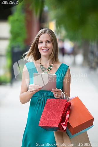 Image of Woman With Shopping Bags And Digital Tablet