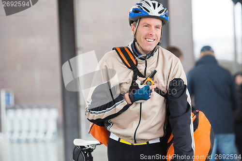 Image of Male Cyclist With Courier Bag Using Walkie-Talkie