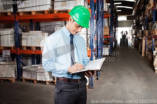 Image of Supervisor Writing Notes At Warehouse