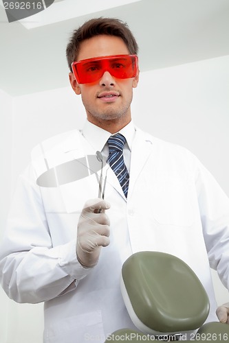 Image of Young Dentist Holding Tools